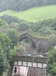 SX23432 Arch in medieval wall over railway in the rain.jpg